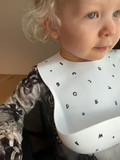 Mushie silikoninen ruokalappu (white letters)